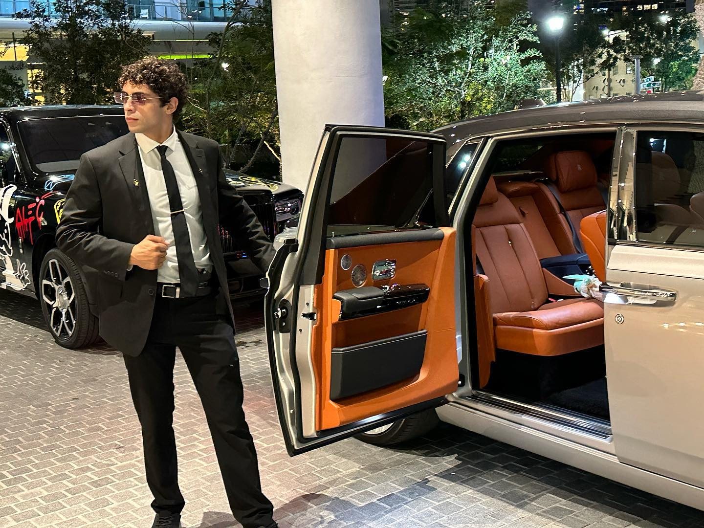 Spectrum Florida Security agent holding a Rolls-Royce door on a Miami night, Cullinan behind